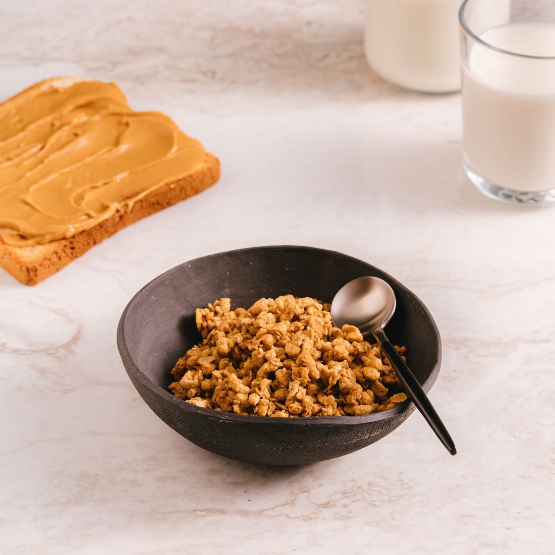 Bát granola và bánh mì bơ đậu phộng cho bữa sáng