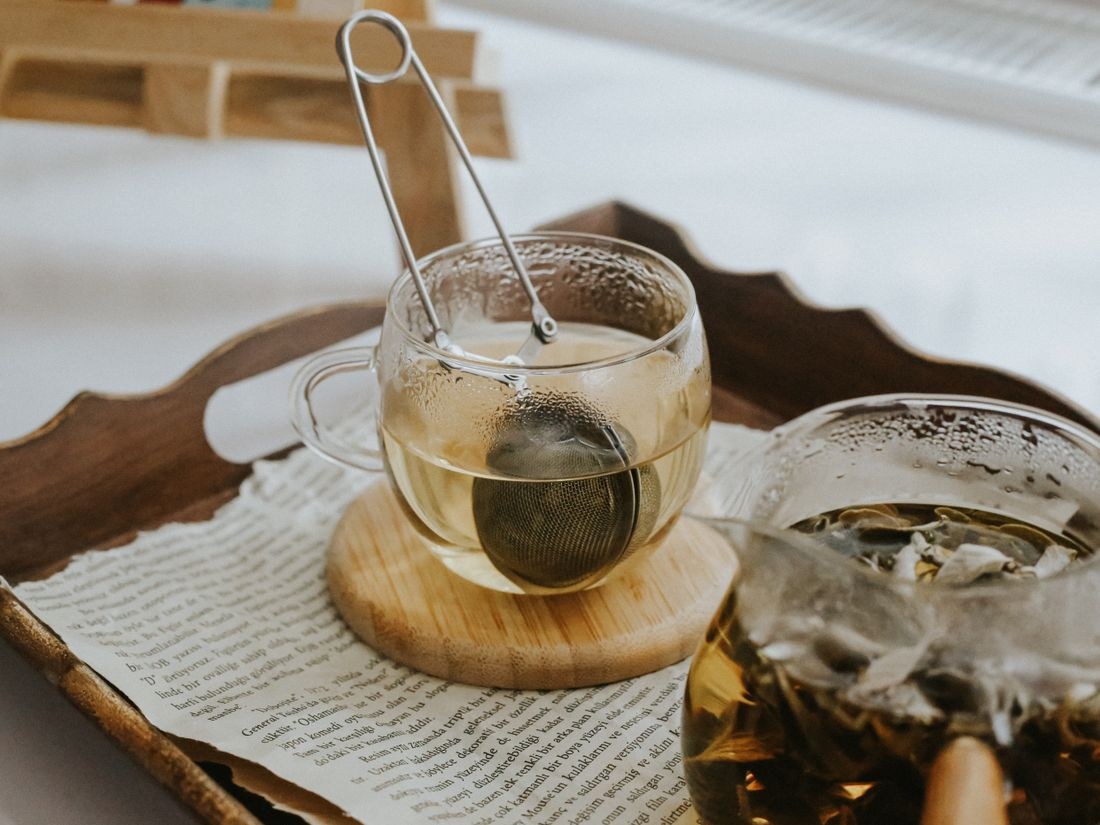 Cốc trà thảo mộc ấm trên khay gỗ